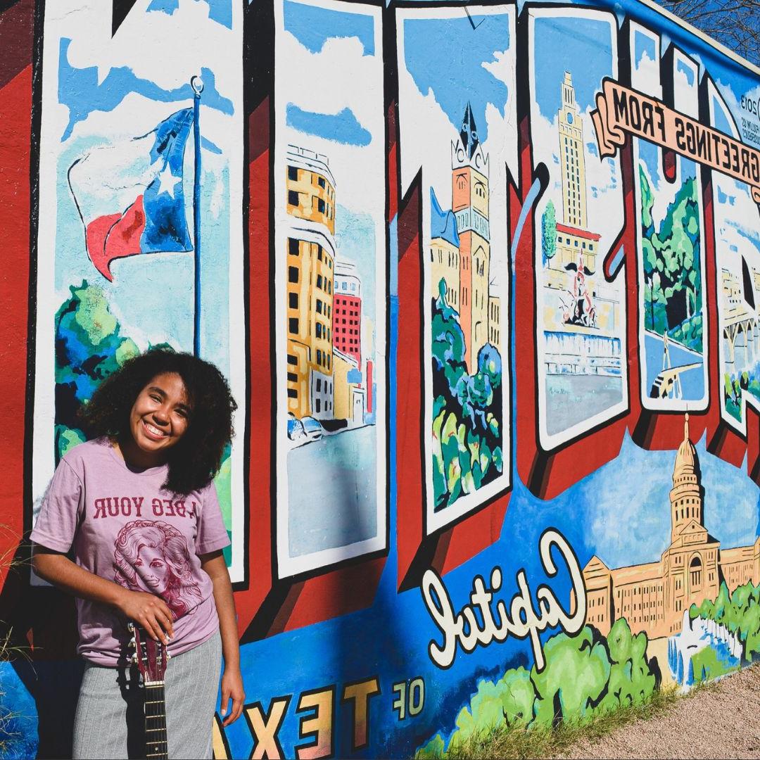 Renae Walker-Zamora posing with an Austin, TX mural